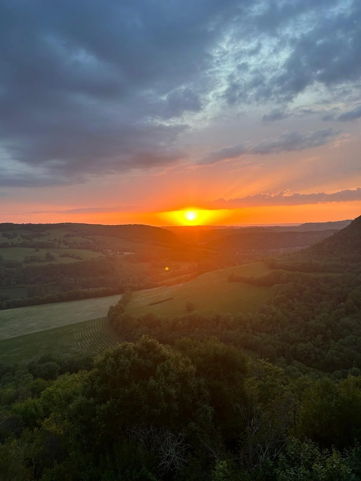 Sunset glowing over the wooded valleys below Puycelsi in South West France